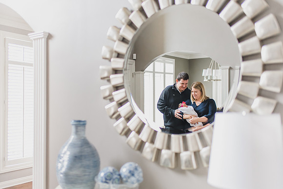 Newborn in mirror with mom and dad