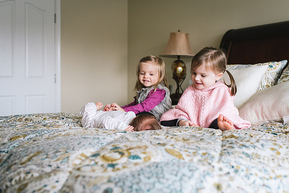 Kids on bed with newborn