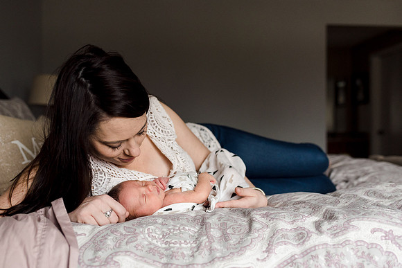 Newborn on bed with mom