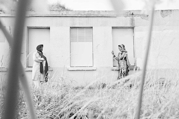 Indian Bride and Groom thru bush at building